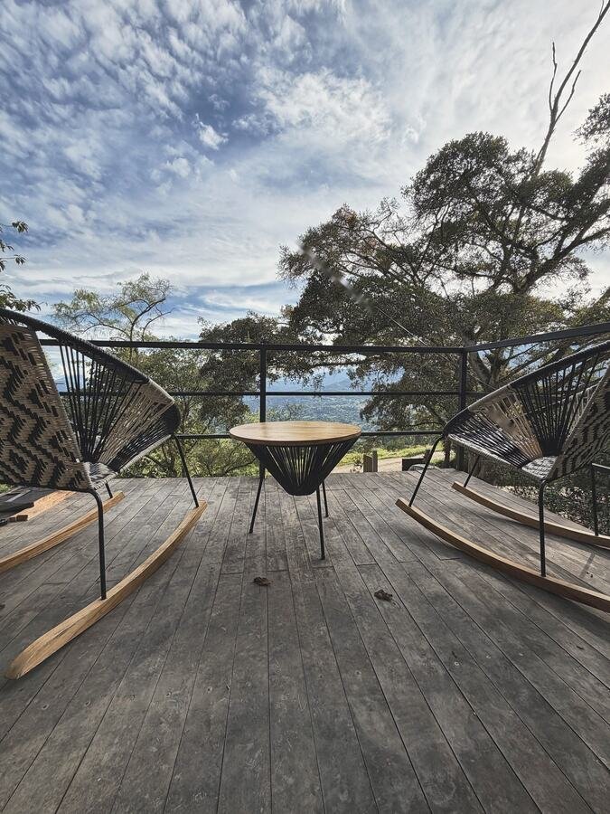 Terraza de madera con mecedoras y vista al valle