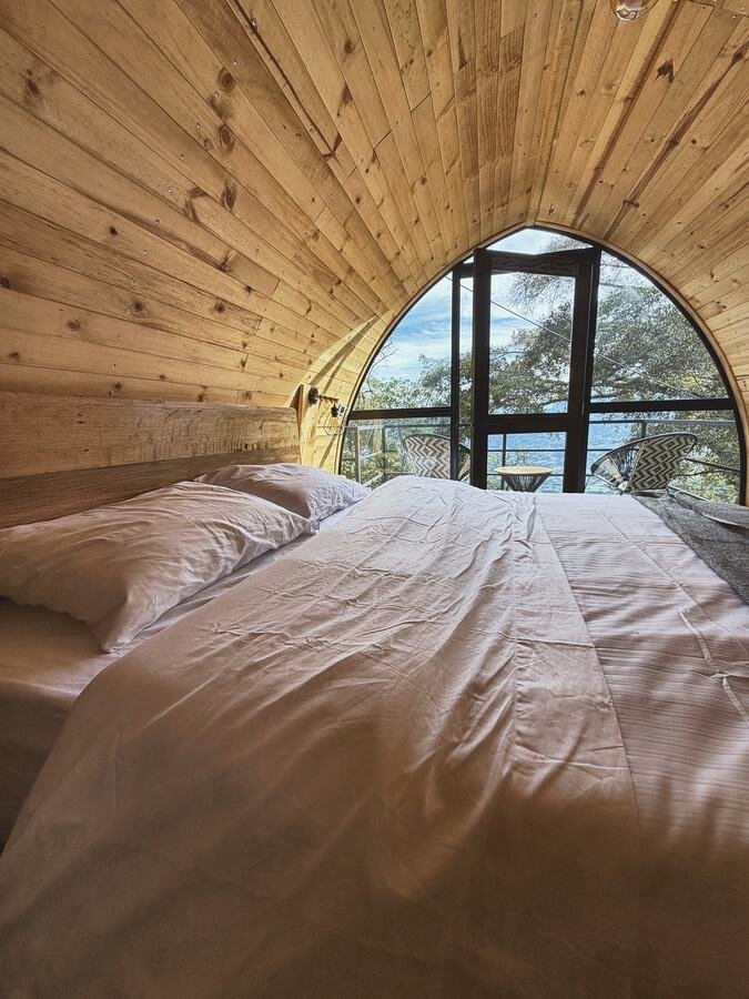 Baño en madera con lavamanos y ventana al pasto
